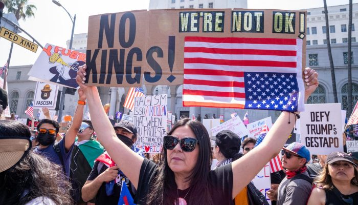111408737-demonstrators-hold-signs-as-they-protest-the-trump-administration-during-the-no-kings-rall.jpeg